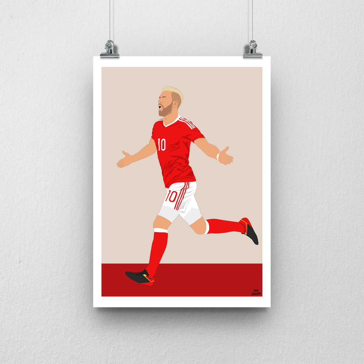 Aaron Ramsey Wales print, running with his arms out in celebration, with a beige and red background and white border.