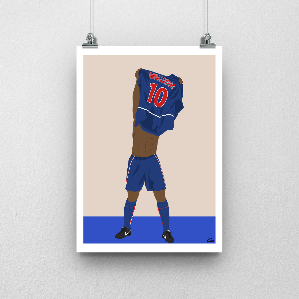 Ronaldinho art print, lifting his PSG shirt over his head with Ronaldinho and number 10 visible on the back, against a beige background with a white border and blue base.