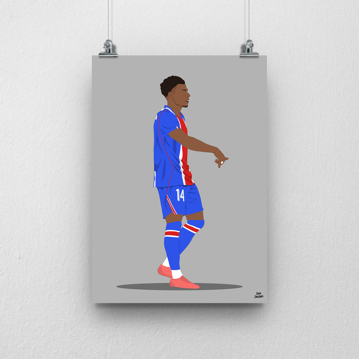 Désiré Doué in PSG's blue kit with a red central stripe, pointing downwards in celebration, against a grey background.