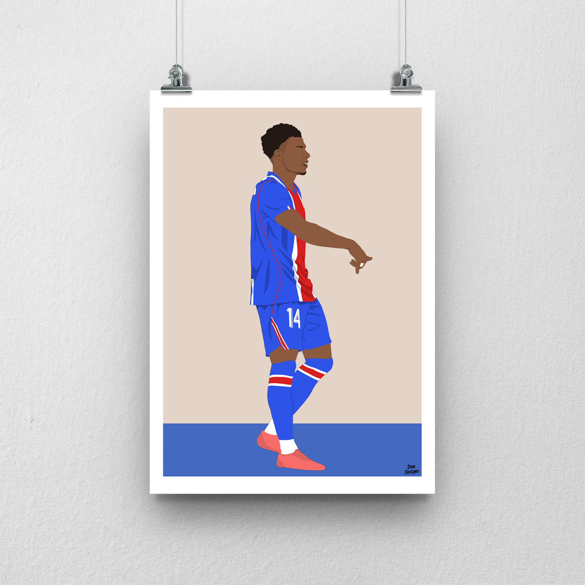 Désiré Doué in PSG's blue kit with a red central stripe, pointing downwards in celebration, against a beige background with a white border and blue base.