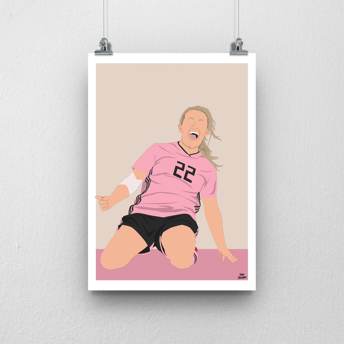 Erin Cuthbert sliding on her knees in Scotland’s pink number 22 shirt, illustrated with a beige background, pink base and white border.