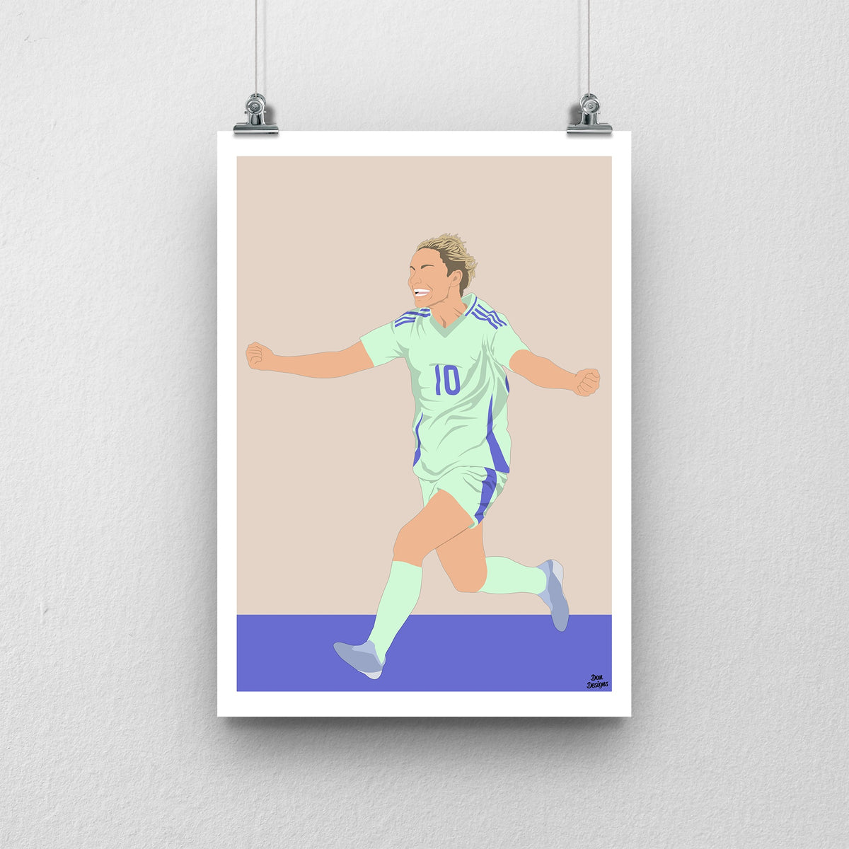 Jess Fishlock Wales print showing her arms-out celebration in the green away kit, with a beige and purple design and white border.