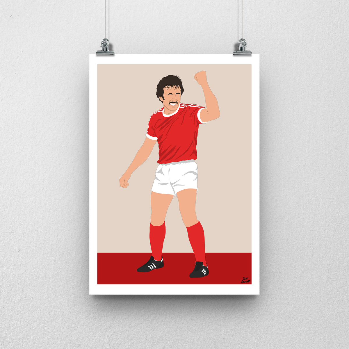 Joey Jones Wrexham print, raising his fist in the red Wrexham shirt, with a beige and red background and white border.