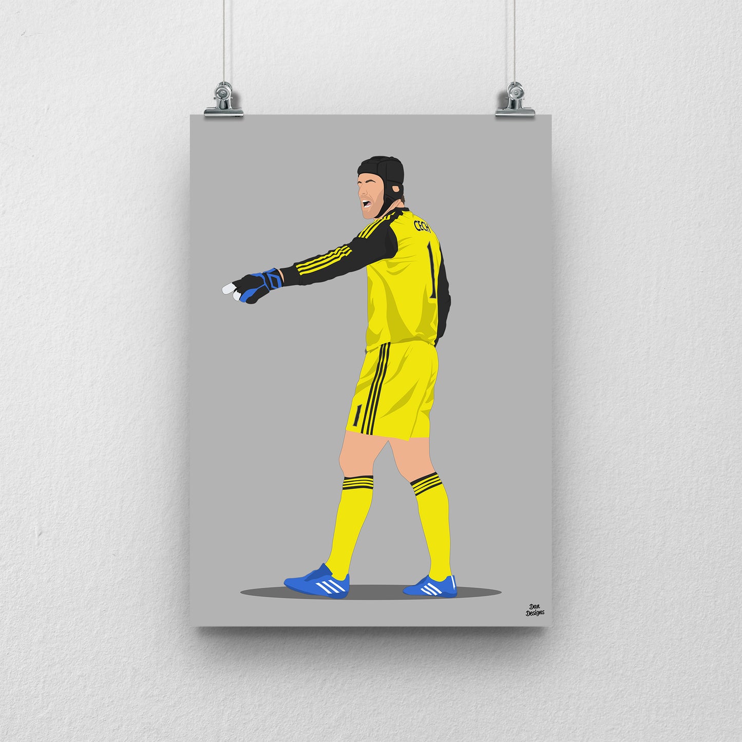 Petr Čech Chelsea art print, pointing across the pitch in a yellow goalkeeper kit, gloves and black protective headgear, with a grey background.