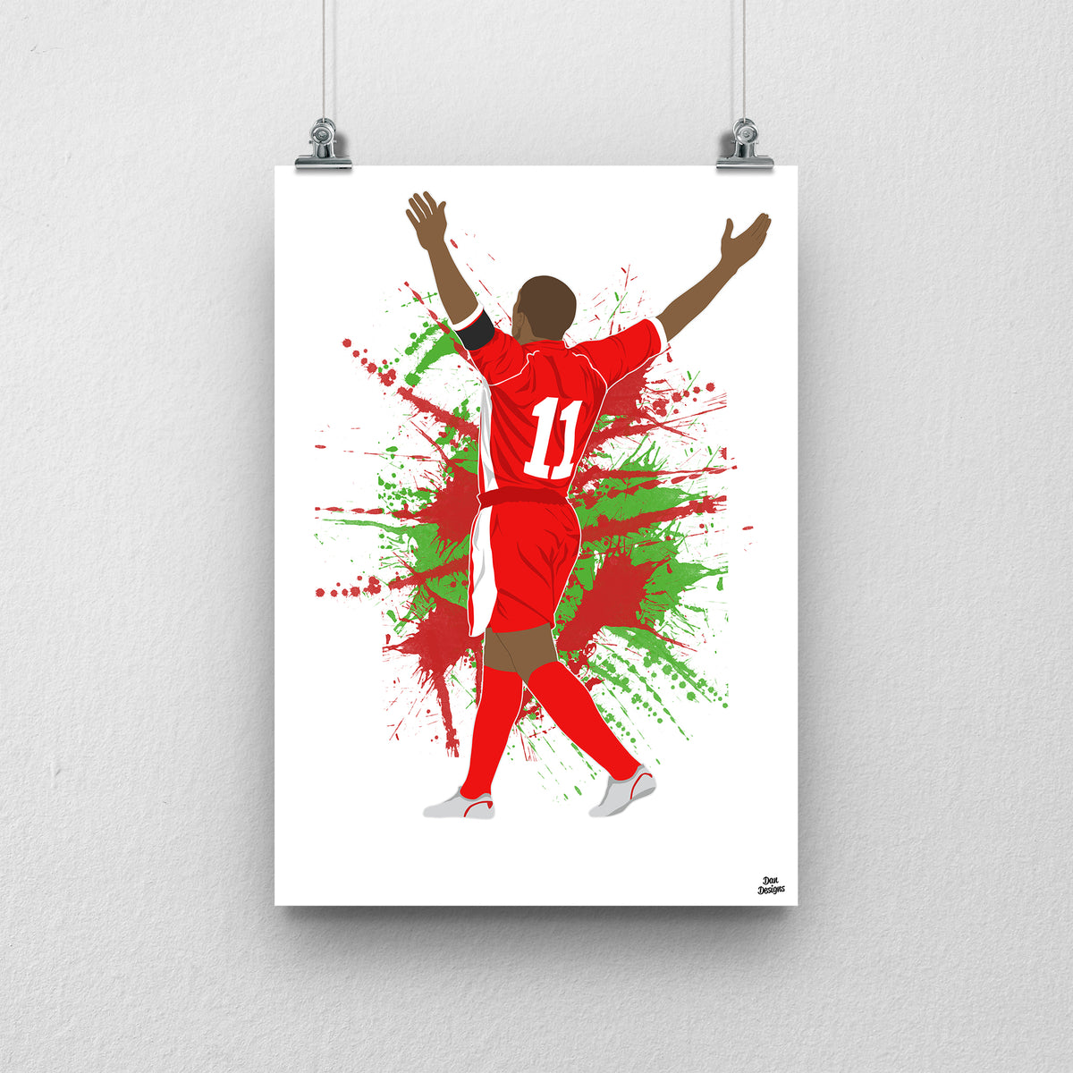 Robert Earnshaw Wales print, celebrating with both arms raised, viewed from behind, on a red and green paint-splatter background.