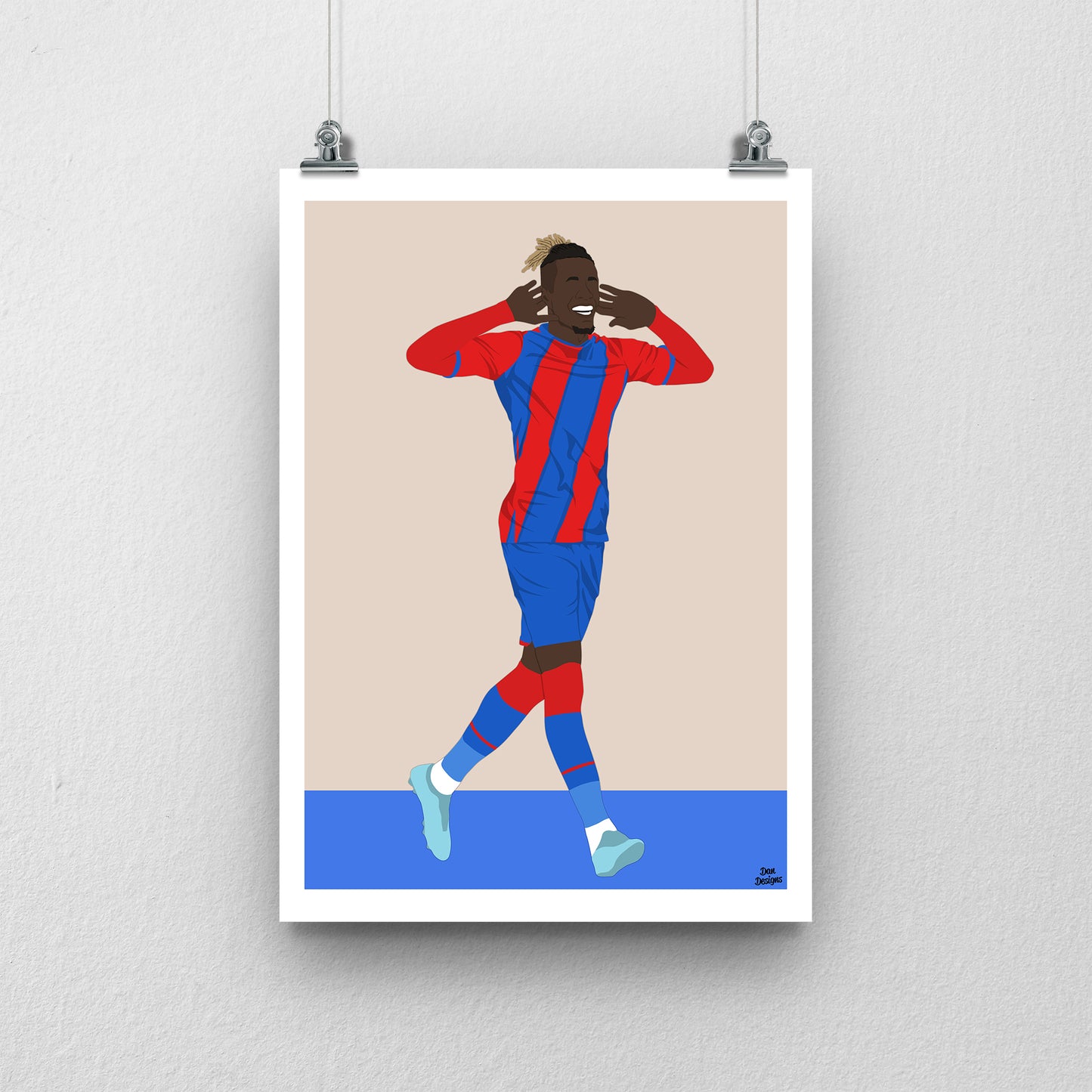 Wilfried Zaha Crystal Palace art print, celebrating with both hands beside his ears in the red-and-blue kit, with a beige background, white border and club-colour base.