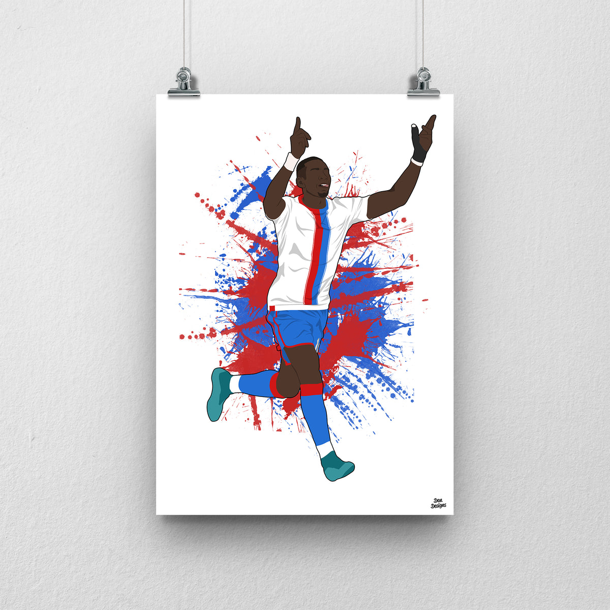 Yannick Bolasie Crystal Palace art print, celebrating with both hands pointing upwards in a white shirt with red-and-blue stripes, against a red-and-blue paint-splatter background.