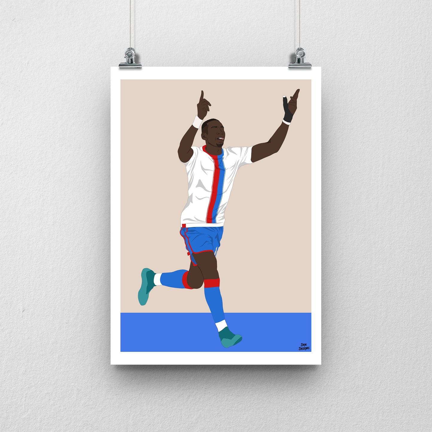 Yannick Bolasie Crystal Palace art print, celebrating with both hands pointing upwards in a white shirt with red-and-blue stripes, against a beige background, white border and blue base.